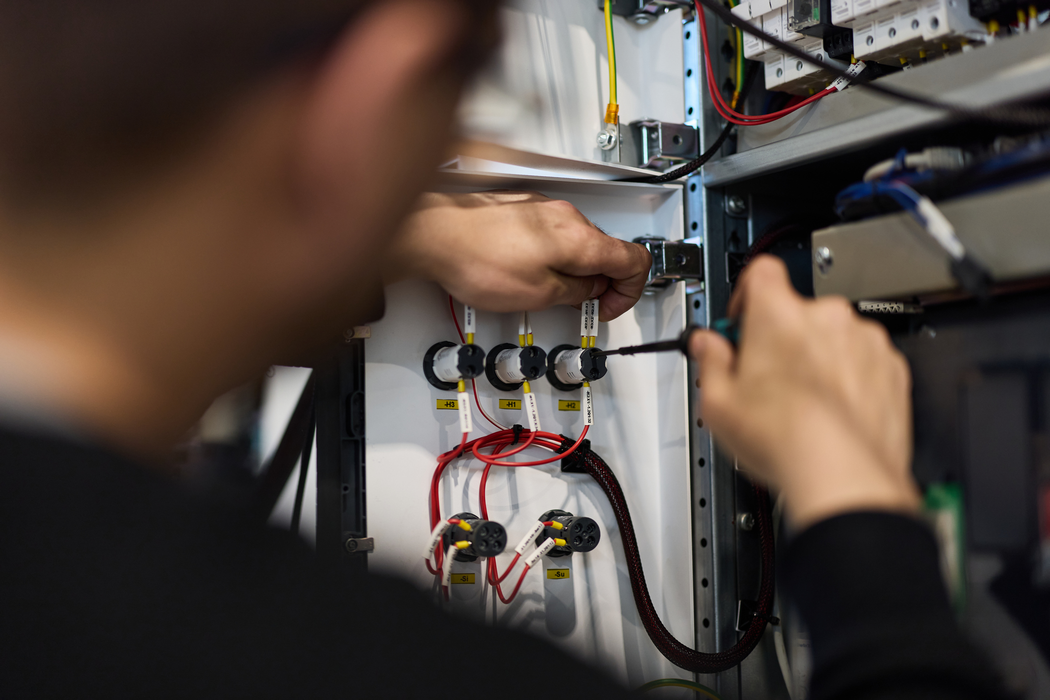 Monteur bezig met installatiewerk in een technische kast